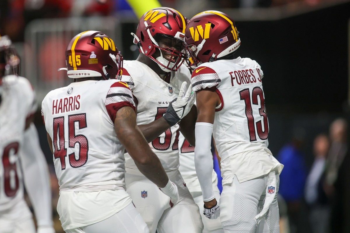 Oct 15, 2023; Atlanta, Georgia, USA; Washington Commanders linebacker Jamin Davis (52) reacts after an interception with linebacker De'Jon Harris (45) and cornerback Emmanuel Forbes (13) against the Atlanta Falcons in the second half at Mercedes-Benz Stadium.